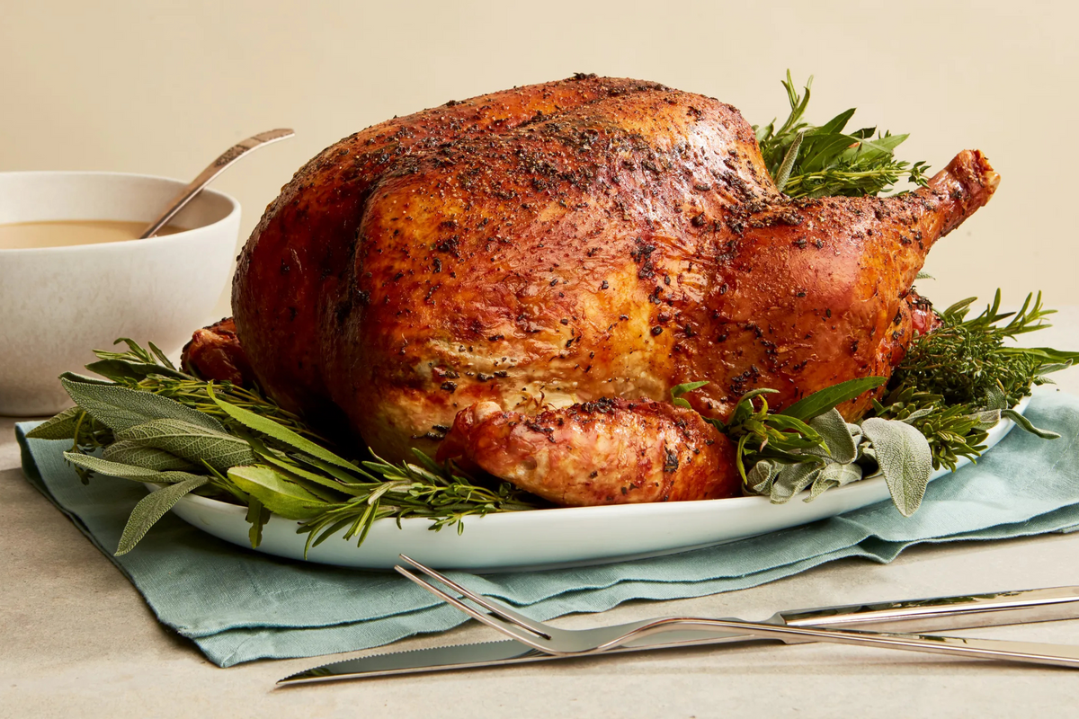 A delicious roasted turkey with herbs on a plate, paired with a cup of aromatic coffee.