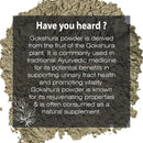 Gokshura Powder fact card with a dark semi-transparent overlay on a macro close-up of a mound of coarse grey-green Tribulus terrestris fruit powder on a white background, featuring white botanical line art and text noting its Ayurvedic fruit origin, urinary tract health support, and vitality-promoting and rejuvenating properties as a natural supplement.