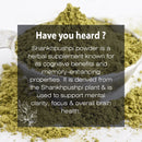Shankhpushpi Powder fact card over a close-up of olive-green herbal powder in a glass bowl, spotlighting its Ayurvedic role as a brain tonic for memory enhancement, mental clarity, and focus support.