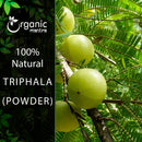 Organic Mantra 100% natural Triphala Powder product Image featuring a close-up of ripe Amla (Indian gooseberry) fruits hanging from a tree with lush, feathery foliage.